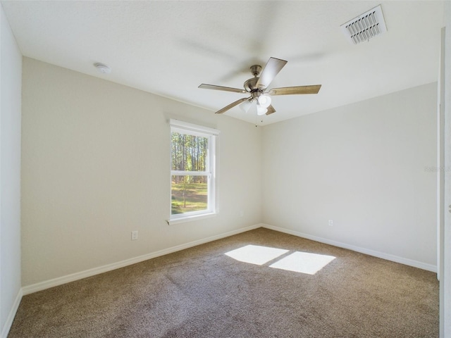 unfurnished room with ceiling fan and carpet