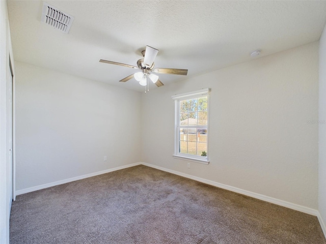 empty room featuring ceiling fan, carpet floors, and a textured ceiling