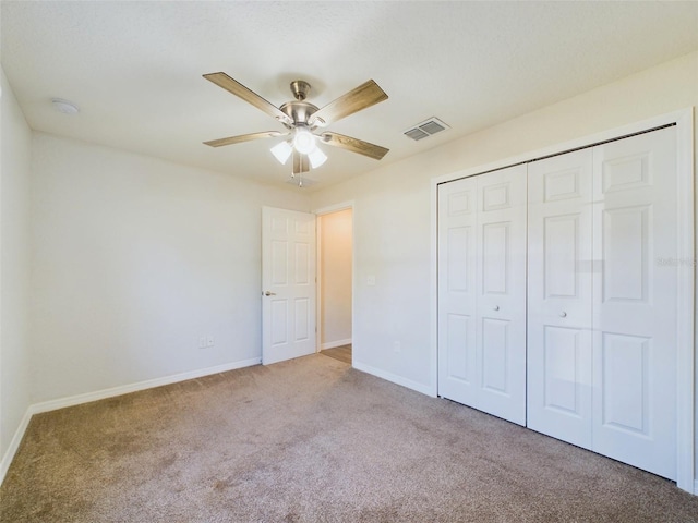 unfurnished bedroom with ceiling fan, light colored carpet, and a closet