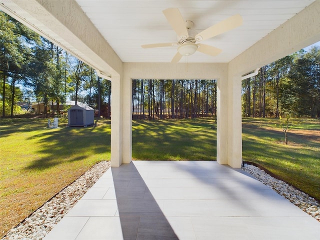 view of patio featuring ceiling fan and a storage shed