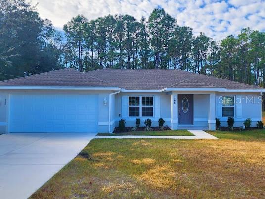 ranch-style house featuring a front yard and a garage