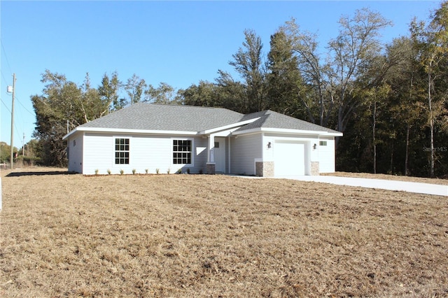 single story home featuring a garage and a front yard