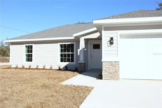 property entrance with a garage and a lawn