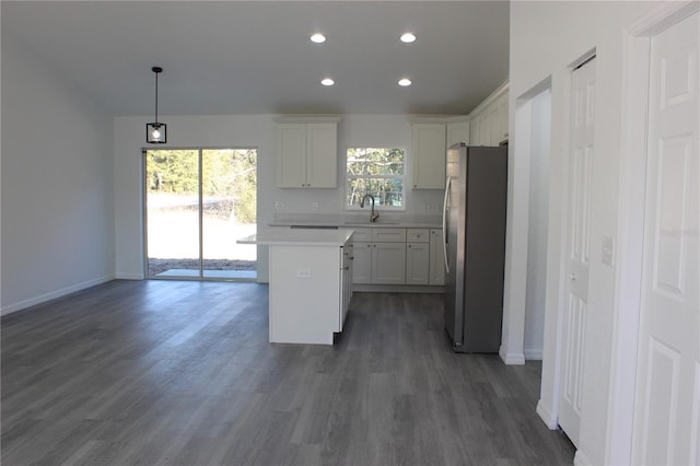 kitchen featuring hanging light fixtures, white cabinetry, a center island, and stainless steel fridge