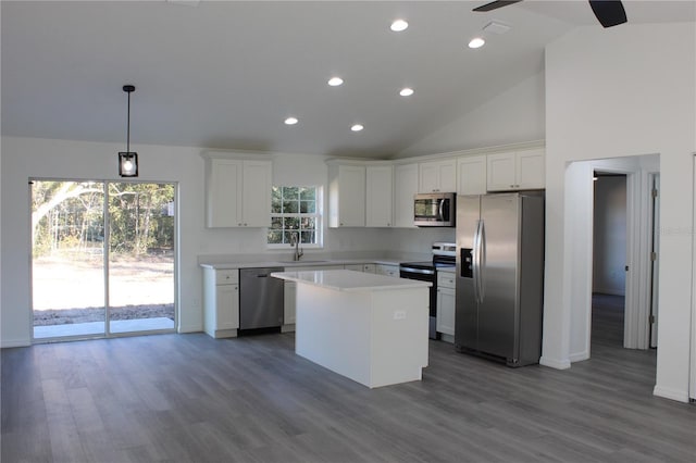 kitchen featuring a kitchen island, appliances with stainless steel finishes, white cabinetry, sink, and dark wood-type flooring