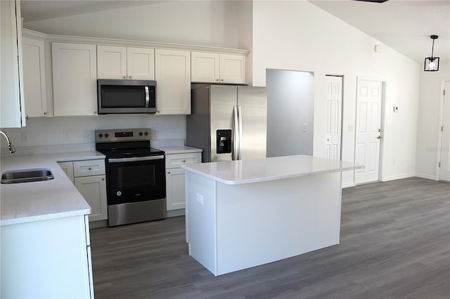 kitchen with a kitchen island, decorative light fixtures, white cabinetry, sink, and stainless steel appliances