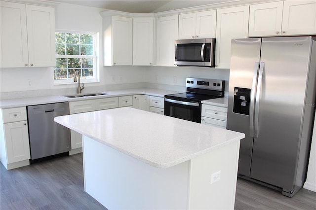 kitchen featuring sink, a center island, light hardwood / wood-style flooring, appliances with stainless steel finishes, and white cabinets