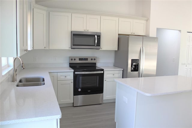 kitchen with white cabinetry, stainless steel appliances, light hardwood / wood-style floors, and sink