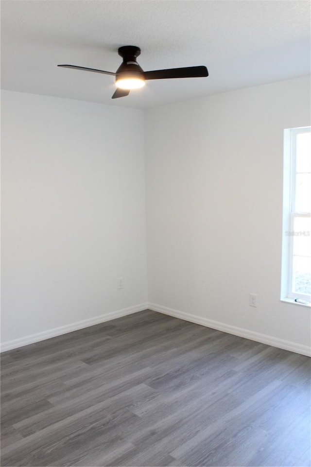 empty room with ceiling fan and dark hardwood / wood-style flooring