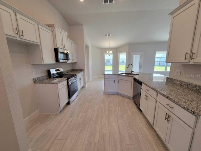 kitchen with white cabinetry, stainless steel appliances, sink, kitchen peninsula, and light stone counters