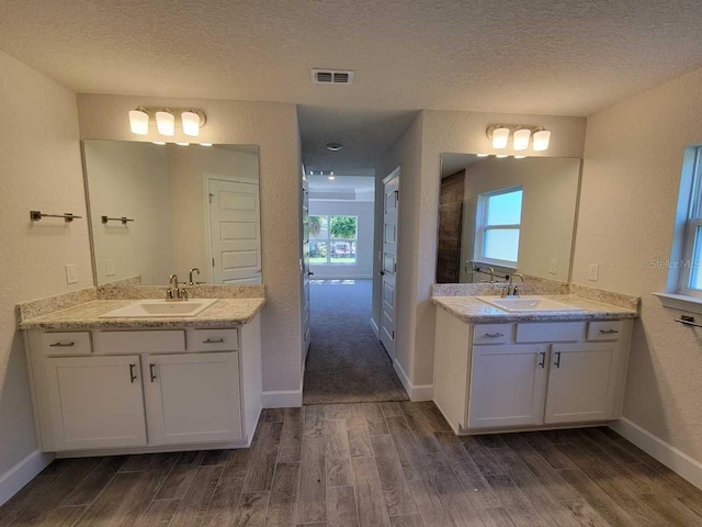 bathroom featuring hardwood / wood-style flooring, a textured ceiling, and vanity