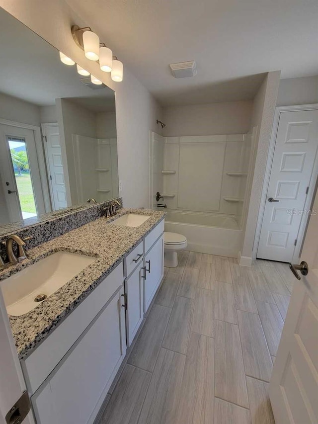 full bathroom with toilet, vanity, and tub / shower combination