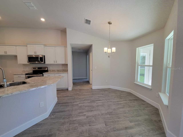 kitchen featuring stainless steel appliances, hanging light fixtures, white cabinets, light stone counters, and sink