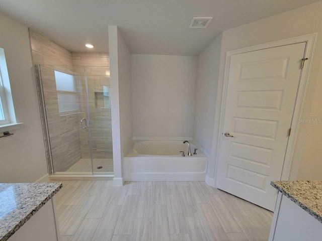 bathroom featuring plus walk in shower and vanity