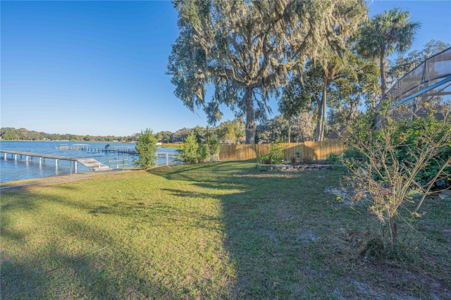 view of yard with a water view and a dock