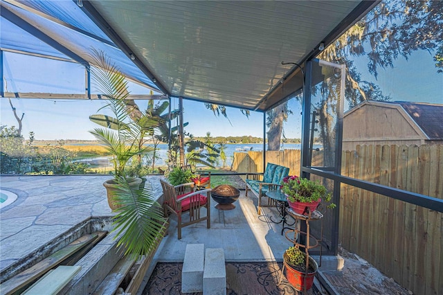 view of patio with a fire pit and a water view