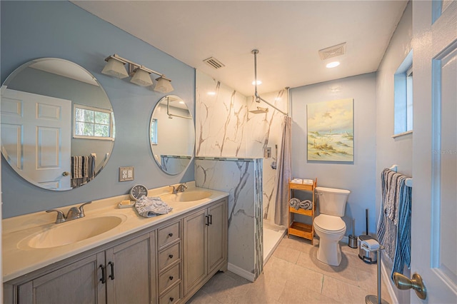 bathroom with tile patterned flooring, vanity, toilet, and walk in shower