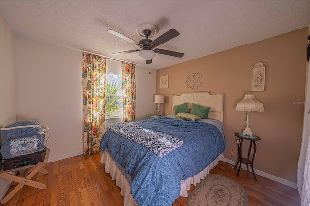 bedroom with ceiling fan, a textured ceiling, and hardwood / wood-style flooring