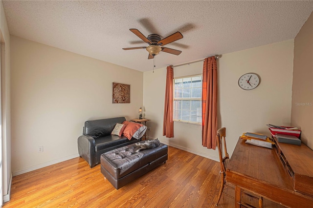 sitting room featuring a textured ceiling, light hardwood / wood-style floors, and ceiling fan