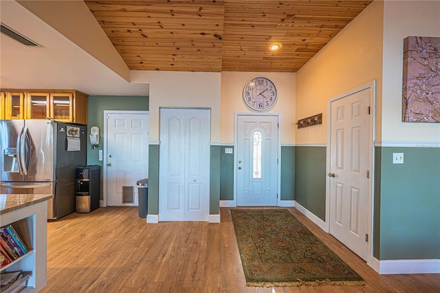 entryway featuring light wood-type flooring, wooden ceiling, and vaulted ceiling