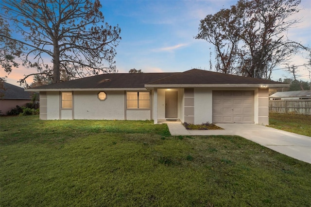 ranch-style house featuring a garage and a lawn