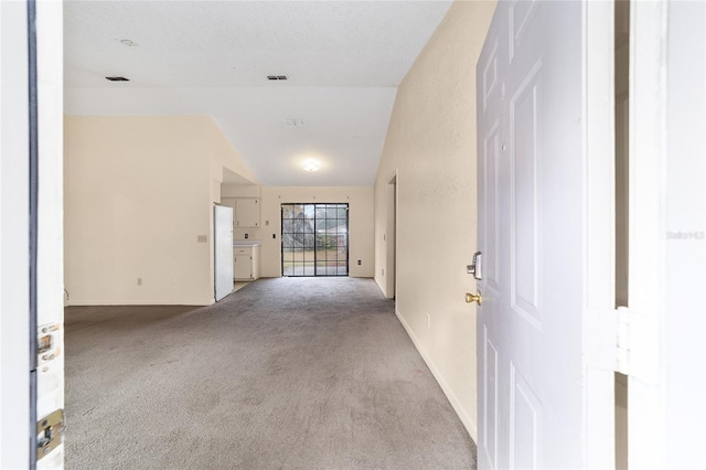 empty room featuring lofted ceiling and light carpet