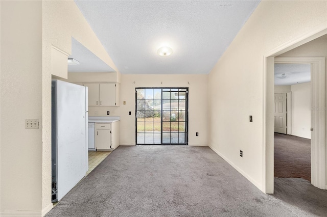 unfurnished living room with light carpet and a textured ceiling