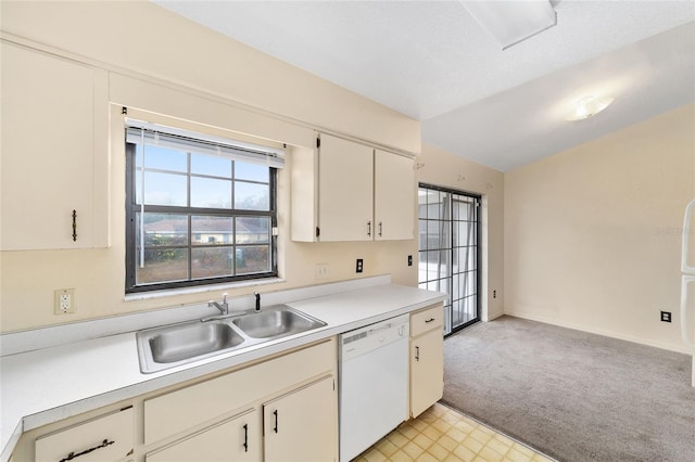 kitchen with sink, white dishwasher, light colored carpet, lofted ceiling, and white cabinets