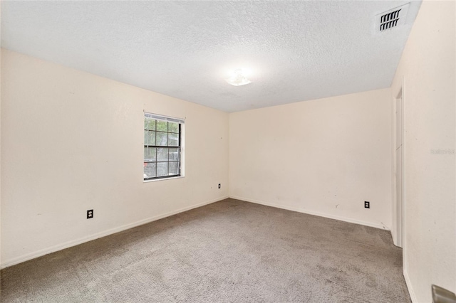 carpeted spare room featuring a textured ceiling