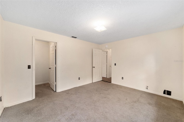 carpeted spare room with a textured ceiling