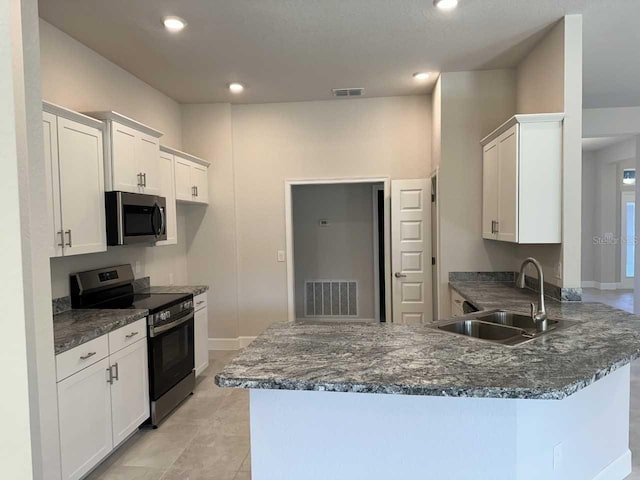 kitchen with kitchen peninsula, appliances with stainless steel finishes, sink, and white cabinetry