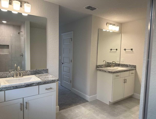 bathroom featuring a tile shower and vanity