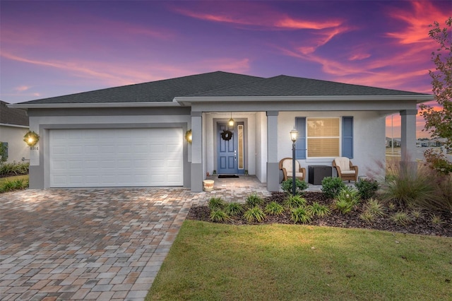 view of front of home with a garage and a lawn