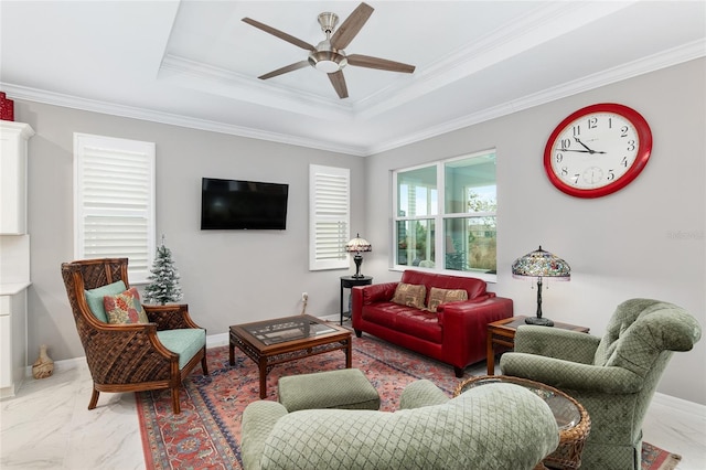 living room with a tray ceiling, ceiling fan, and crown molding