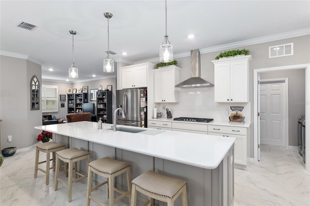 kitchen with a breakfast bar, appliances with stainless steel finishes, wall chimney exhaust hood, and a large island