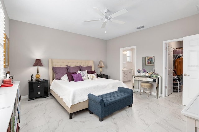 bedroom featuring ceiling fan, ensuite bath, a walk in closet, and a closet