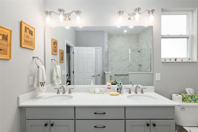 bathroom with a tile shower and vanity