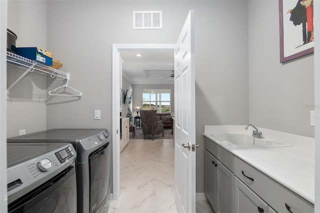 laundry room featuring crown molding, sink, cabinets, and independent washer and dryer