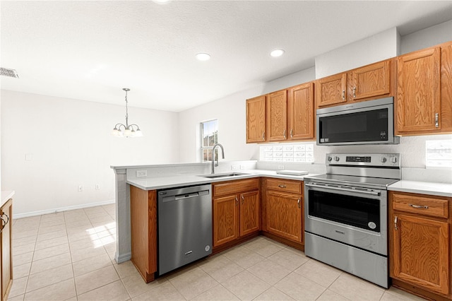 kitchen featuring a healthy amount of sunlight, sink, stainless steel appliances, and an inviting chandelier