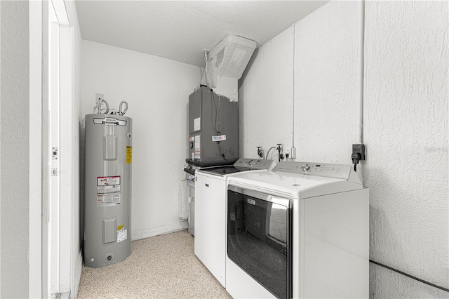 laundry room featuring washing machine and dryer, water heater, and a textured ceiling