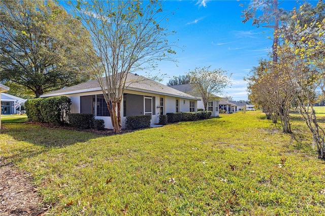 view of side of home with a yard