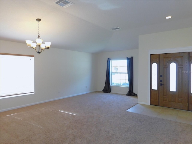 carpeted entryway with a chandelier