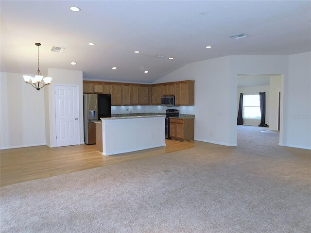 kitchen with pendant lighting, a kitchen island with sink, vaulted ceiling, a notable chandelier, and stainless steel appliances