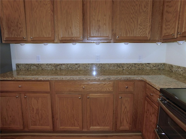 kitchen with electric range and light stone counters