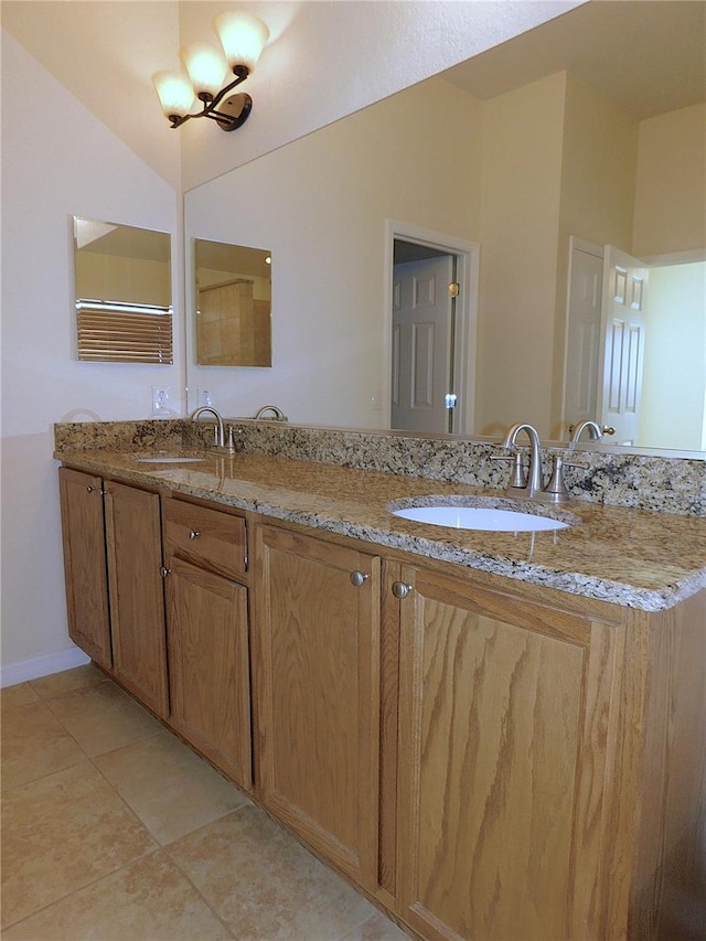 bathroom with tile patterned flooring, vanity, and vaulted ceiling