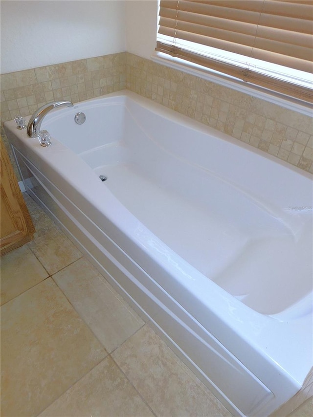 bathroom with tile patterned floors and tiled tub