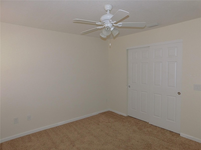 spare room featuring ceiling fan and carpet floors