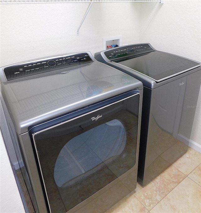 laundry room with separate washer and dryer and light tile patterned floors