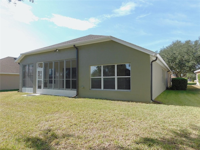 back of property with a sunroom and a yard