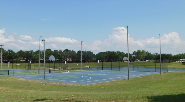 view of basketball court featuring community basketball court, fence, and a lawn